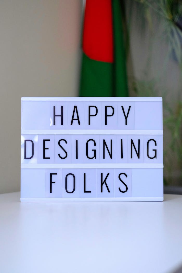contact-img Lightbox sign displaying 'Happy Designing Folks' in an office space.