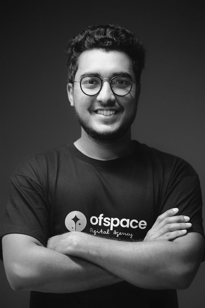 services-img Studio portrait of a smiling young man with eyeglasses in black and white.