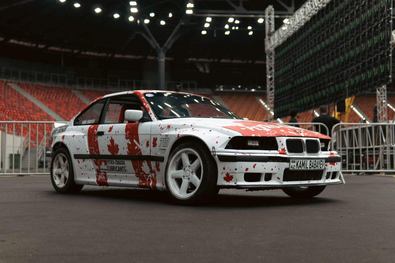 Crafting Captivating Headlines: Your awesome post title goes here A customized car with vibrant paint designs set in a stadium. Ideal for auto enthusiasts.